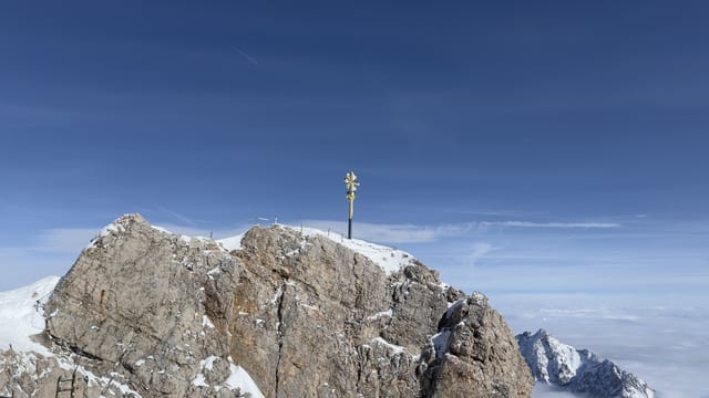 Snow-covered Zugspitze summit beneath a blue sky.